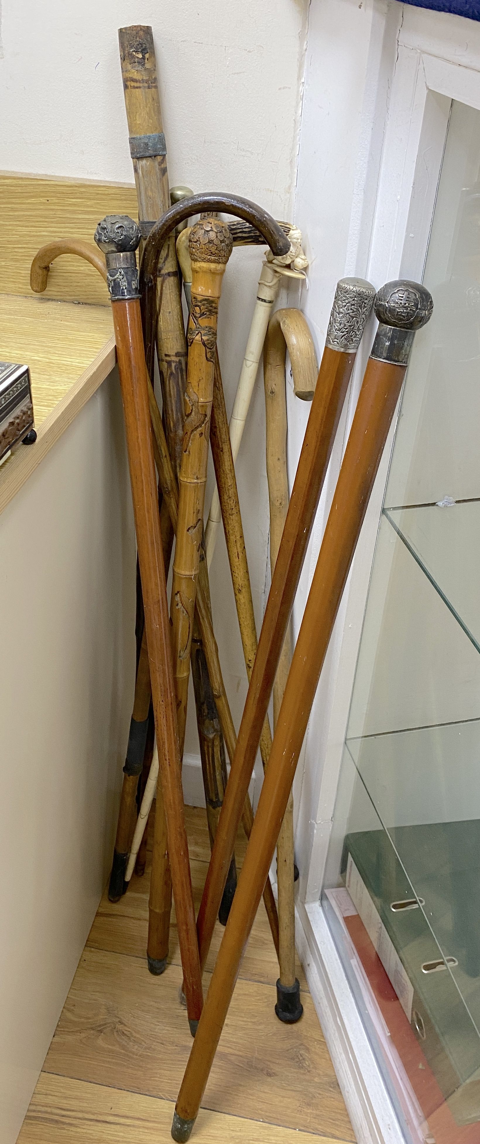 A collection of walking sticks, including ivory handles